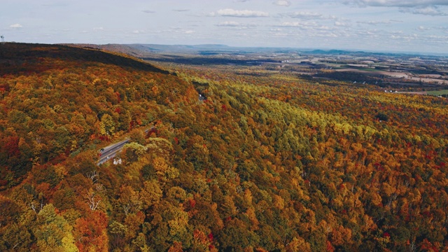 遥远的风景鸟瞰公路上的阿巴拉契亚山脉与遥远的利哈伊山谷，波科诺斯，宾夕法尼亚州，在秋天的傍晚的背景。航拍视频与平移摄像机运动。视频素材