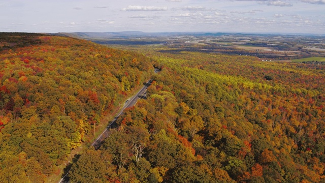 遥远的风景鸟瞰公路上的阿巴拉契亚山脉与遥远的利哈伊山谷，波科诺斯，宾夕法尼亚州，在秋天的傍晚的背景。航拍视频与向前摄像机运动。视频素材