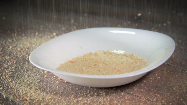 将饼干屑和面粉洒在厨房的盘子上，慢动作视频素材