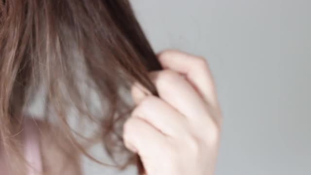 女孩抱着一缕头发正面观，有脱发的观念视频素材