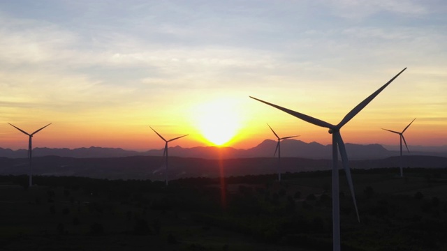 4k鸟瞰图的风力涡轮机在日落，风车，能源生产-绿色技术。可再生能源解决方案视频下载