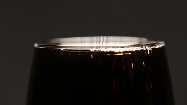 可乐苏打饮料与冰在玻璃杯特写。微距在灰色背景视频下载