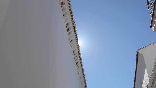 太阳在蓝天下经过安达卢西亚屋顶上的一排瓦片视频素材