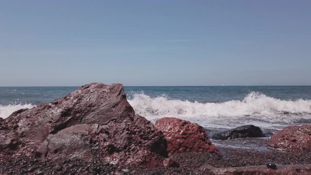 地中海的海浪冲击着圣托里尼岛的岩石，慢镜头视频素材