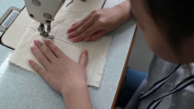 亚洲华裔女时装大学生在大学工作坊做服装缝纫项目视频素材