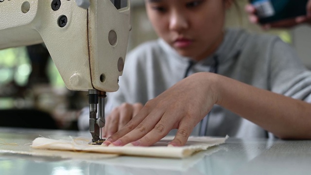 亚洲华裔女时装大学生在大学工作坊做服装缝纫项目视频下载