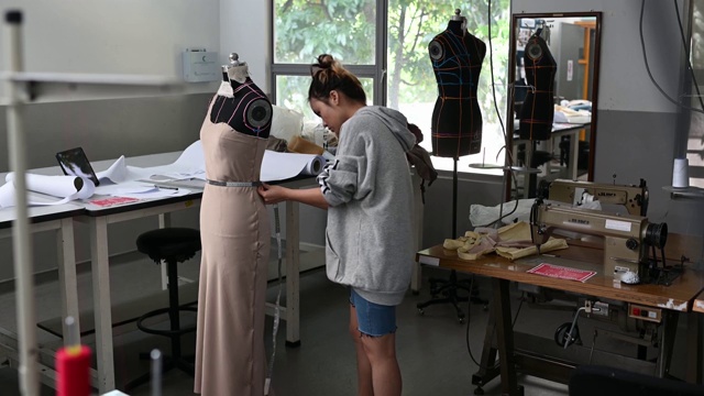 亚洲华裔女性时装大学生测量和工作服装项目在学院工作坊视频素材