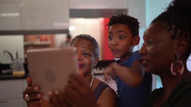 三代人在平板电脑上看电影视频下载