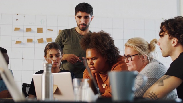多种族的年轻男女计算机程序员在共同的工作空间里通过笔记本电脑讨论视频下载