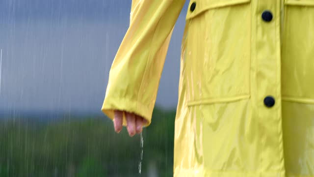 SLO MO女人穿着雨衣享受雨视频下载