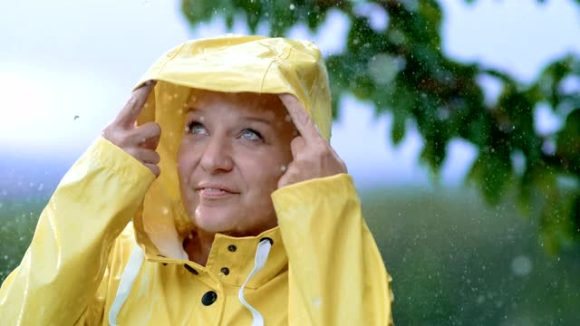 超级SLO MO中年妇女在雨衣享受雨视频下载