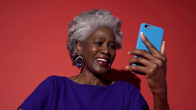 一个穿蓝色衣服的老妇人在讲电话视频素材