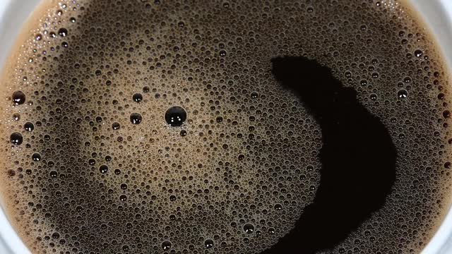 可溶解的咖啡泡沫在杯子中旋转视频素材