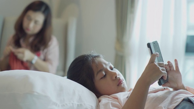 快乐的小女孩使用手机。视频下载