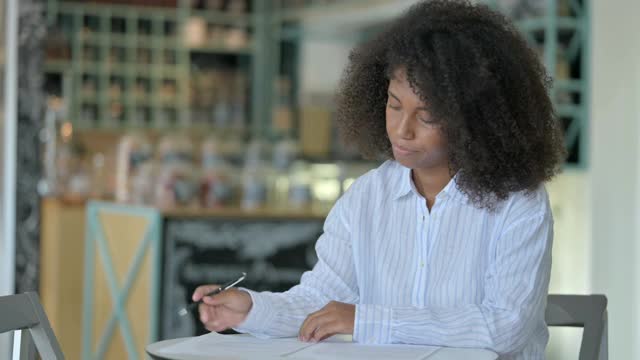 严肃的年轻非洲女商人在咖啡馆里做文书工作视频素材