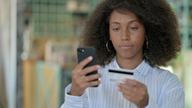 非洲女商人在智能手机上成功在线支付的肖像视频素材
