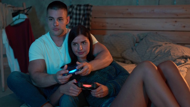 一对情侣在卧室里一起玩电子游戏视频素材