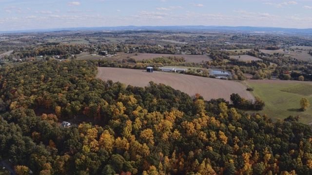 宾夕法尼亚州里海镇附近的农田，与森林，拼凑的田地，村庄，和农场之间的山。航拍视频与向后相机运动。视频素材