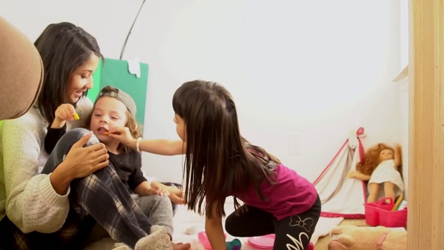单身母亲和她的孩子在家里玩视频素材