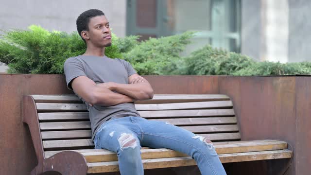 沉思的年轻非洲人坐在长凳上思考视频下载