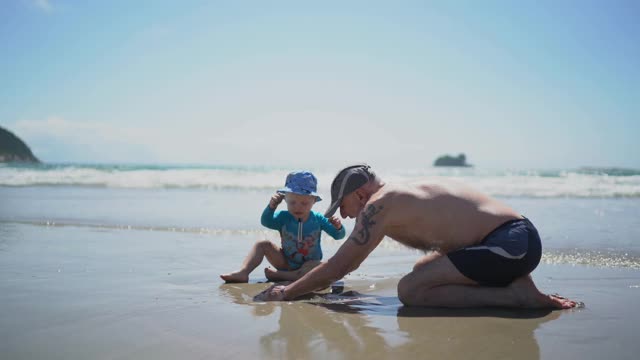 小男孩和他爷爷在海滩上玩视频下载
