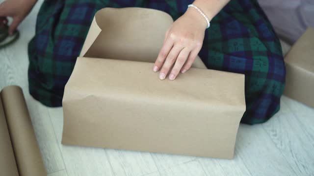 节日，新年和圣诞节概念-特写女性的手正在包装礼物视频下载