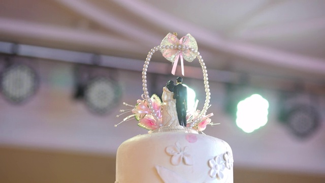 优雅的婚礼蛋糕与新娘和新郎雕像在婚宴上视频素材
