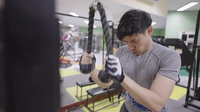 运动员在健身房用器械锻炼手臂和肩膀。视频下载
