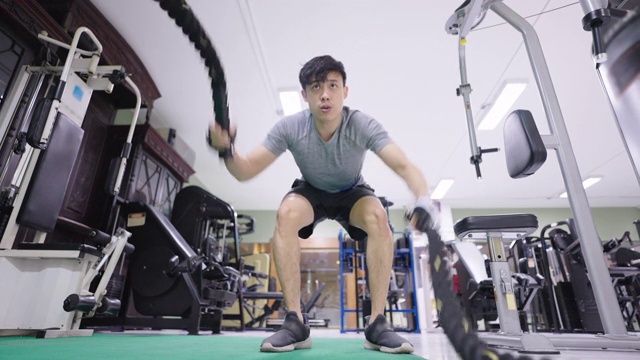 男健身教练在健身房做格斗绳训练。视频素材