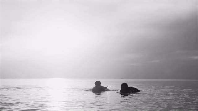 一群亚洲朋友的剪影与冲浪板和跳跃放松暑假在海滩上快乐地跑视频素材