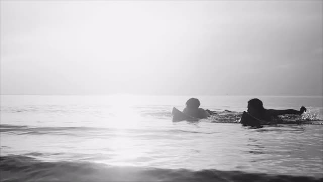 一群亚洲朋友的剪影与冲浪板和跳跃放松暑假在海滩上快乐地跑视频素材