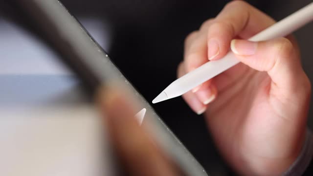 近距离的女性手使用数字笔书写在数字平板屏幕上视频下载