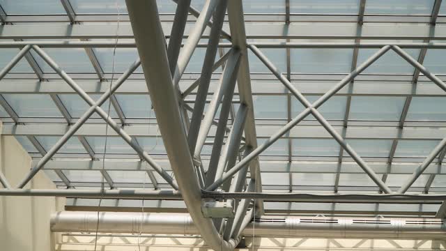 现代建筑的屋顶。摘要高科技建筑背景下，内部金属框架结构的玻璃屋顶带有可锁窗分段视频素材