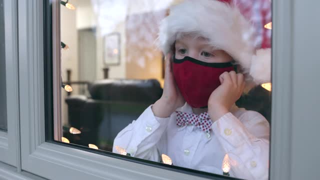 2019冠状病毒病大流行期间，小男孩透过家庭窗户看世界视频下载