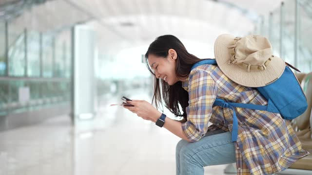 女游客在机场使用智能手机视频素材