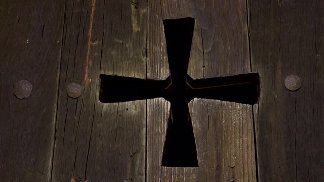 宗教十字架形状的洞在古老的古色古香的木制教堂百叶窗视频下载