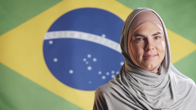 在巴西国旗上摆姿势的戴着头巾的快乐女人的肖像视频下载