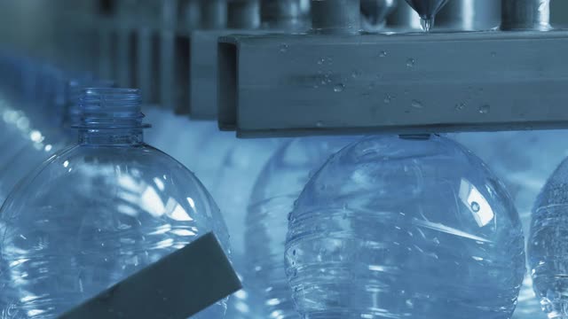 在工厂的自动生产线输送带上灌装塑料瓶视频素材