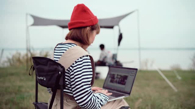 周末坐在露营帐篷里用笔记本电脑工作的自由女视频下载