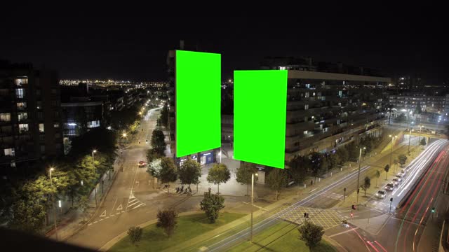 大广告牌用绿屏做广告，在现代化的建筑中，繁忙的霓虹路口，交通的跳板，城市城市的夜晚视频下载