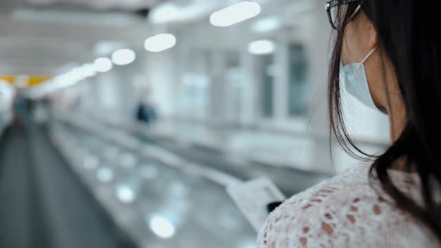 年轻的亚洲女子在机场航站楼使用智能手机视频素材