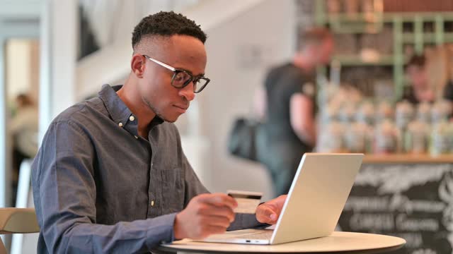非洲人在咖啡馆的笔记本电脑在线支付失败视频素材