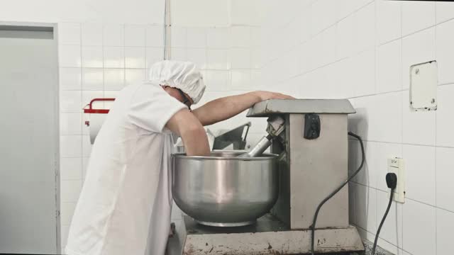 实时视频的中年西班牙面食制造者操作机器在工厂视频素材