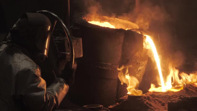 惊人的钢铁厂工人将液态钢倒入模具视频素材
