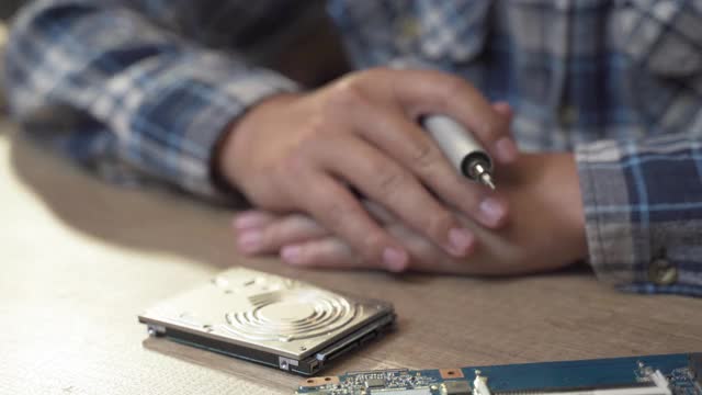 十几岁的男孩修理笔记本电脑的硬盘视频素材