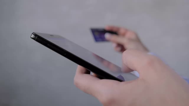 近距离观察:女性使用智能手机和信用卡进行网上购物视频素材