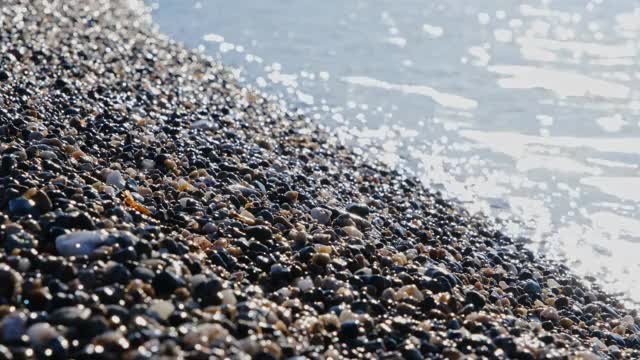 沙滩上的小卵石被海浪刮得光滑干净。旅游的概念视频素材