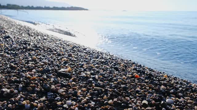 沙滩上的小卵石被海浪刮得光滑干净。旅游的概念视频素材