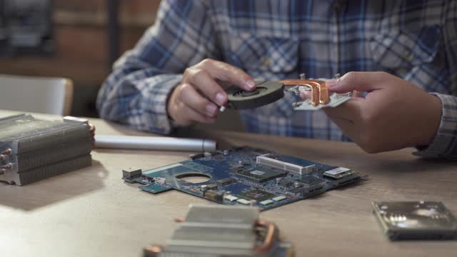 十几岁的男孩修理笔记本电脑的硬盘视频素材