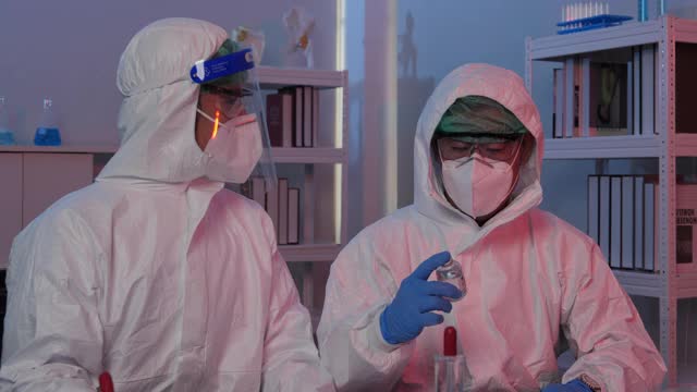 两位科学家合作成功了，一位科学家拿着一个疫苗瓶。视频下载